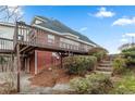 Back of house with a wooden deck, brick exterior, and stone steps leading up the landscaped yard at 816 Ivy Ridge Dr, Loganville, GA 30052