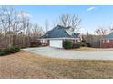 View of house showing yard and drive. House features a multi-car garage and mature trees in the surrounding area at 816 Ivy Ridge Dr, Loganville, GA 30052