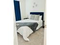 Cozy bedroom features carpet, a navy headboard, and soft gray accent pillows at 2633 Coventry Sw St, Atlanta, GA 30331