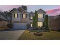 Two-story home at twilight with a landscaped yard, brick accents, and two car garage at 379 Peachstone Way, Lawrenceville, GA 30043