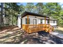 Cozy exterior of home featuring a charming covered porch with wood railing and outdoor ceiling fan at 4739 Cook Sw Rd, Stockbridge, GA 30281