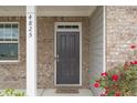 Inviting front entrance features a classic dark door and brick facade with address numbers on the pillar at 4825 Layton Drive, Lithia Springs, GA 30122