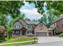 Stunning two-story brick home with a three-car garage and well-manicured lawn at 1351 Ashbury Park Dr, Hoschton, GA 30548