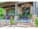 Inviting front porch with stone accents, comfortable seating and stylish double door entry at 1351 Ashbury Park Dr, Hoschton, GA 30548