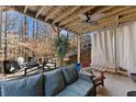 Relax on the covered deck with a fan, outdoor seating, swing, and scenic views of the wooded backyard at 1351 Ashbury Park Dr, Hoschton, GA 30548