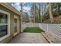 Private back patio with artificial turf and a white lattice fence with stone accents at 250 Peachtree Hollow Ct, Atlanta, GA 30328