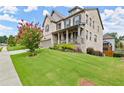 Beautiful two-story home with well-maintained lawn, flowering tree, and inviting curb appeal at 4316 Woodland Bank Blvd, Buford, GA 30518