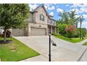 Lovely two-story brick home featuring a manicured lawn, three-car garage, and long driveway at 4316 Woodland Bank Blvd, Buford, GA 30518