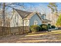 Side view of a charming two-story home with a fenced yard and well-manicured landscaping at 101 Hardwood Ln, Canton, GA 30115
