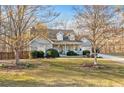 Inviting two-story home with a well-maintained lawn, mature trees, and a cozy front porch at 101 Hardwood Ln, Canton, GA 30115