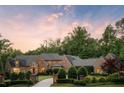 Elegant brick home with wrought iron fence, lush landscaping, and circular drive at 4520 Garmon Nw Rd, Atlanta, GA 30327
