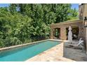 Inviting backyard pool area with brick patio, outdoor seating, and views of mature trees at 4520 Garmon Nw Rd, Atlanta, GA 30327