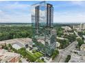 Stunning exterior view of modern high-rise condominium building with glass facade and surrounding greenery at 3630 Peachtree Ne Rd # 3302, Atlanta, GA 30326
