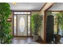 Bright foyer with decorative front door, hardwood floors, textured ceiling, and neutral wall paint at 820 Hounds Ridge Ct, Lawrenceville, GA 30043