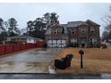 Charming brick home featuring an attached two-car garage and a well-manicured front yard with a comfortable chair at 279 Valley Rd, Lawrenceville, GA 30044