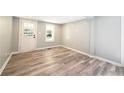 Bright, freshly painted room with new flooring and plenty of natural light from the windows and exterior door at 6886 Upshaw Mill Rd, Douglasville, GA 30134