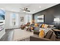 Stylish living room with hardwood floors, a gray sectional, and a modern accent wall at 531 Burton Dr, Alpharetta, GA 30009