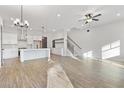 Open-concept living space with hardwood floors, stairs, kitchen view and modern lighting at 937 Willingham Dr # 7, Hapeville, GA 30354