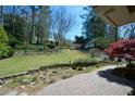 Beautiful landscaped yard with a stone retaining wall, red maple tree, and brick patio at 2112 Starfire Ne Dr, Atlanta, GA 30345