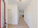 Inviting hallway with light wood floors leading to a bright living area featuring a fireplace at 310 Tuggle Court, Woodstock, GA 30188