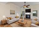Bright living room with a fireplace, ceiling fan, and lots of natural light from large windows at 310 Tuggle Court, Woodstock, GA 30188