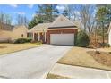 Well-maintained single-story brick home featuring an attached two-car garage, a cozy front porch, and a paved driveway at 564 Grand Ashbury Ln, Sugar Hill, GA 30518