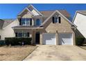 Traditional two-story home with brick accents, a well-kept lawn, and a spacious two-car garage at 1295 Leisure Lake Dr, Lawrenceville, GA 30044