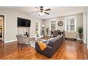 Inviting living room featuring hardwood floors, a comfortable sofa, a ceiling fan, and an adjacent dining area at 300 W Peachtree St # 21K, Atlanta, GA 30305