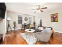 Relaxing living room featuring hardwood floors, modern furniture, natural light from windows, and a ceiling fan at 300 W Peachtree St # 21K, Atlanta, GA 30305