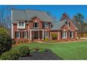 Beautiful two-story brick home with manicured lawn and black mulch landscaping at 3718 Thunder Ne Way, Marietta, GA 30066