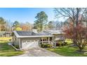 Charming home with solar panels, a metal roof, a garage, landscaping, and a spacious front yard at 5320 Karr Rd, Cumming, GA 30040