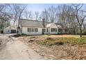 Traditional-style home with a detached garage and a long driveway on a partially wooded lot at 1140 Goodwin Ne Pl, Atlanta, GA 30319