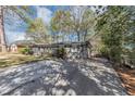 Long, paved driveway leading to a single-story brick home with mature trees and landscaping at 2754 Drew Valley Ne Rd, Atlanta, GA 30319