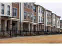 Street view of modern townhome exteriors with brick and board and batten siding and black framed windows at 334 Olmstead Way # 37, Alpharetta, GA 30022