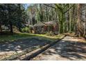 View of home from driveway surrounded by mature trees at 1833 Ridgeland Dr, Decatur, GA 30032