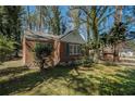 Quaint brick home with green shutters nestled among trees at 1833 Ridgeland Dr, Decatur, GA 30032