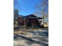 View of a property's backyard with a wooden back porch, chain link fence and weathered exterior at 1033 Mclendon Dr, Decatur, GA 30033