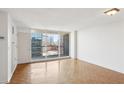 Bright living room featuring wood floors and large windows offering city views at 620 Peachtree Ne St # 1806, Atlanta, GA 30308