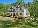 Beautiful two-story home with inviting porch, mature trees, and a glimpse of the backyard pool at 650 Jones Rd, Roswell, GA 30075