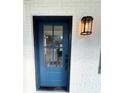 Close-up of a home's blue front door with glass inserts, a black handle set, and a stylish porch light at 175 Jayne Ellen Way, Alpharetta, GA 30009