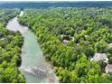 Aerial view of lush green landscaping with a winding river and a collection of beautiful homes at 510 Covington Cv, Alpharetta, GA 30022