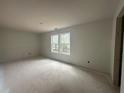 Living room with white walls, concrete floors, and a view of trees through the white-framed windows at 35 Emerald Ln, Covington, GA 30014