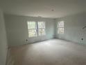 Bright, unfinished living room featuring multiple windows offering natural light and a view of the surrounding trees at 35 Emerald Ln, Covington, GA 30014