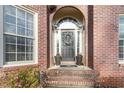 Inviting front entrance with a gray front door, lovely wreath, brick steps, and potted plants at 3770 Summit Gate Dr, Suwanee, GA 30024