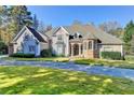 Beautiful two-story home with a circular driveway and well-manicured lawn at 3871 River Mansion Dr, Peachtree Corners, GA 30096