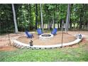 Backyard firepit with seating for four surrounded by lush greenery at 200 Stone Lake Dr, Dallas, GA 30157