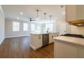 Open-concept kitchen showcases white cabinets, a kitchen island, stainless appliances, and wood floors at 163 Bluffington Way, Marietta, GA 30066