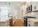 Modern kitchen features white cabinets, stainless appliances, a sleek black faucet, and wood floors at 163 Bluffington Way, Marietta, GA 30066