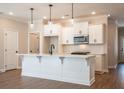 Bright, eat-in kitchen with white cabinetry, stainless appliances, and a large center island at 163 Bluffington Way, Marietta, GA 30066