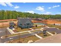 New construction home with a green roof, tennis courts, a covered pavilion, and landscaping on a sunny day at 188 Balsam Dr, Dallas, GA 30157
